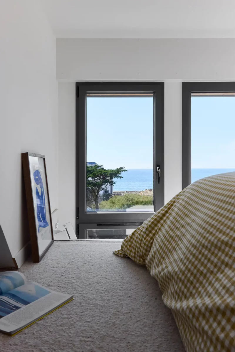 Vue sur l'océan depuis les fenêtres d'une chambre minimaliste à Batz-sur-Mer.