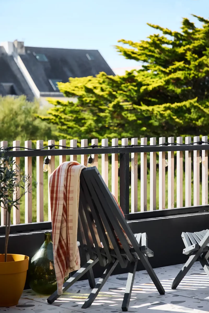 Fauteuil de jardin sur la terrasse en bois de l'extension contemporaine à Batz-sur-Mer.