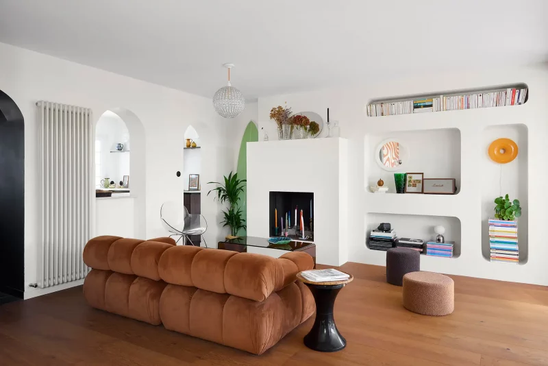 Salon contemporain avec canapé Camaleonda marron, cheminée maçonnée et niches murales.