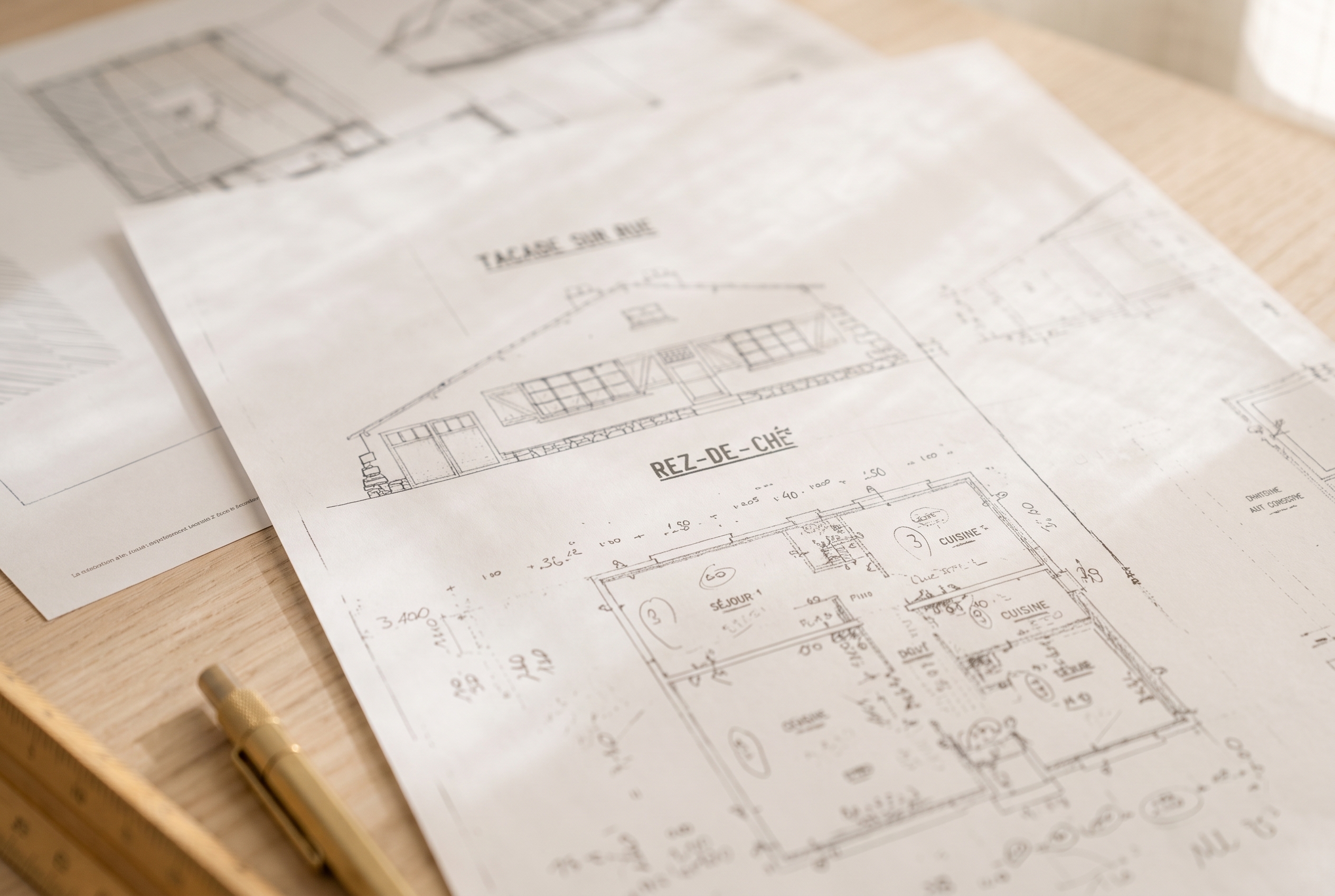 Pièces graphiques d'un permis de construire annotées au crayon : façade sur rue et plan de rez-de-chaussée